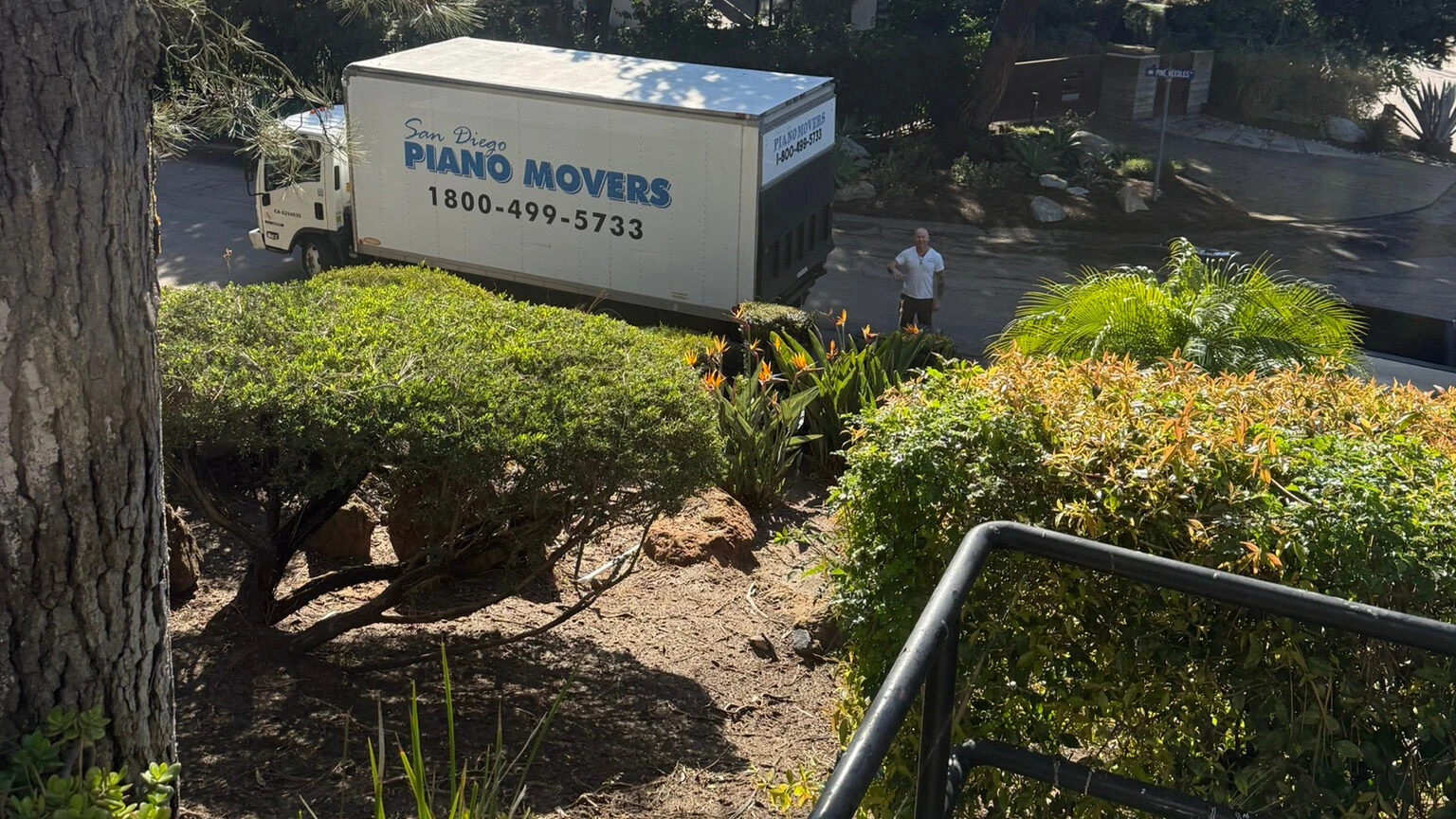Piano movers navigating a staircase with specialized equipment